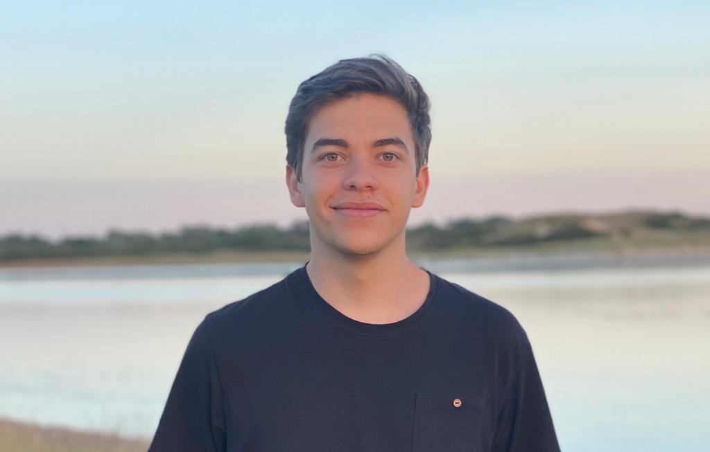 John Bellingall smiling in front of a lake.